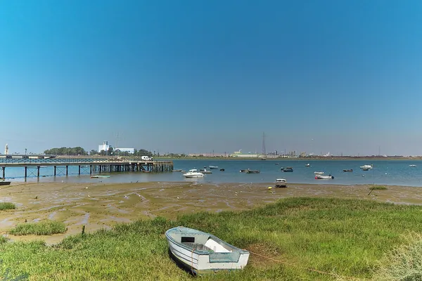 Cuánto cuesta un entierro en Huelva en 2026: la ría del Tinto en Huelva, con el muelle y las barcas en la orilla
