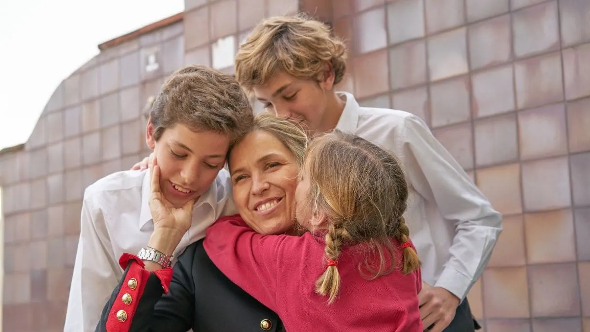 Una madre abrazada por sus tres hijos, la protección familiar del seguro de decesos en Madrid