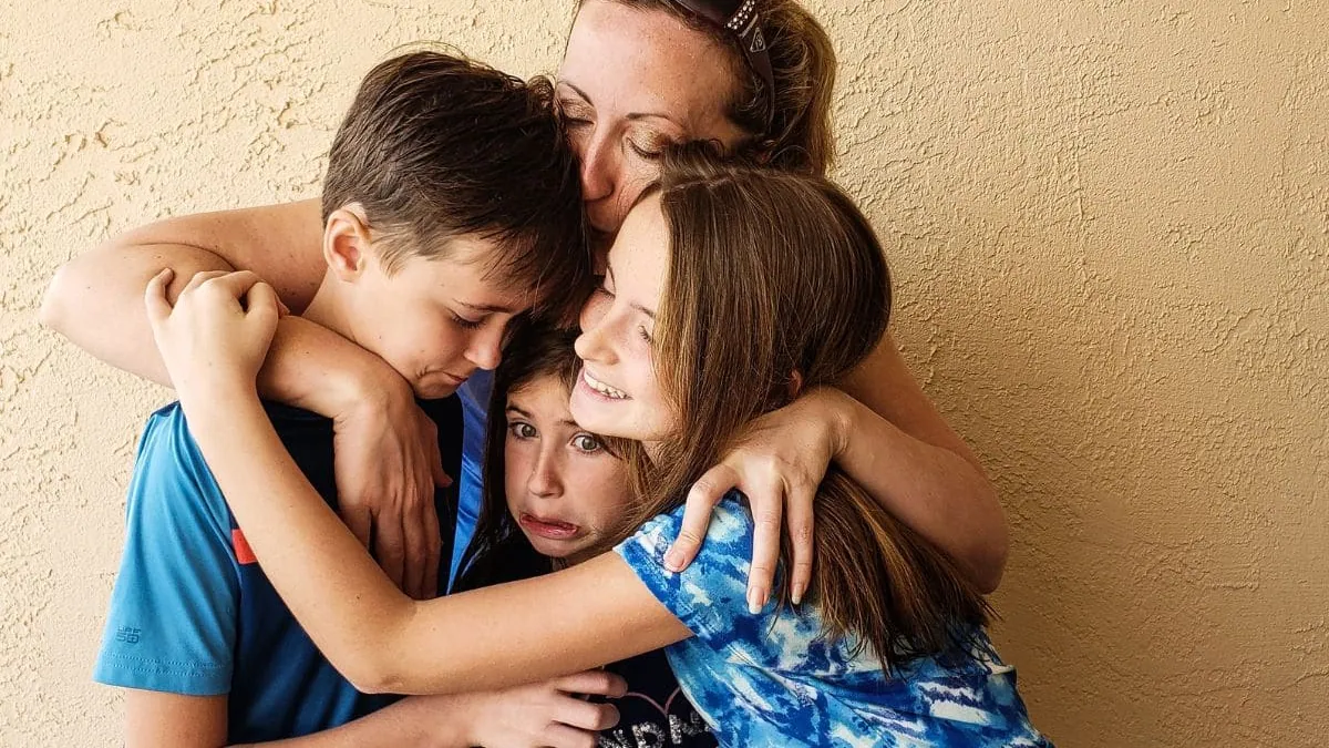 Una madre resguarda a sus tres hijos, una imagen del seguro de decesos online de Preventiva