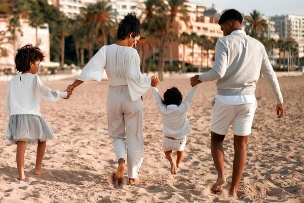 Seguro de decesos para empresas y autónomos: una familia pasea unida por la playa